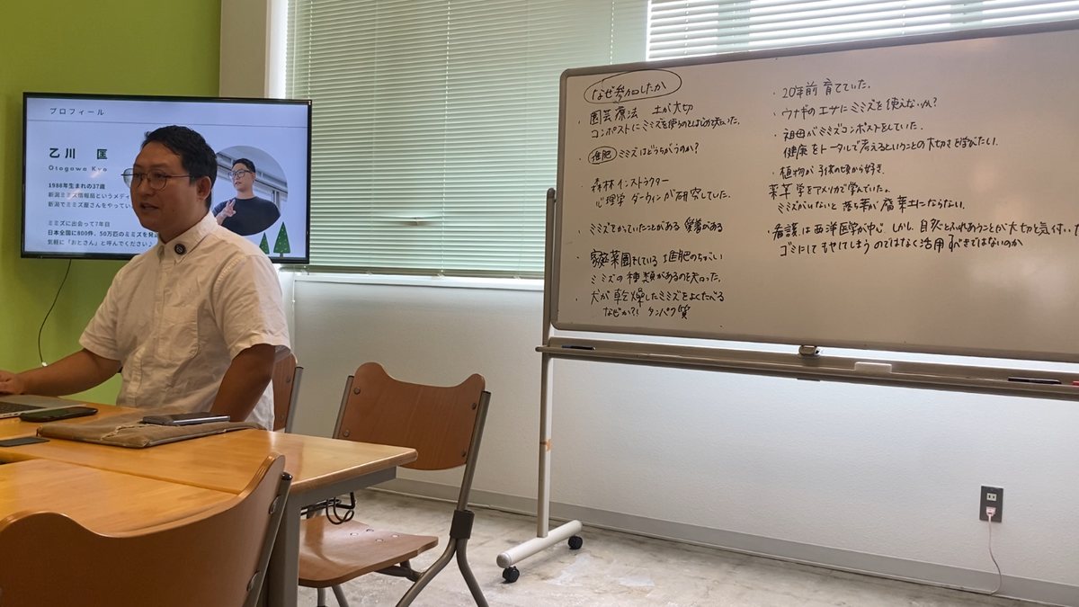 吉備国際大学での講義。参加した方々がミミズに関心を持った理由を書いたホワイトボードの横で話す白河於徒弥